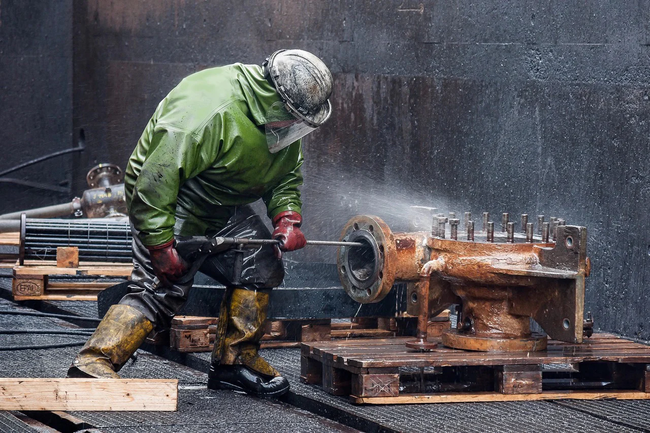 Man using pressure washer on industrial site